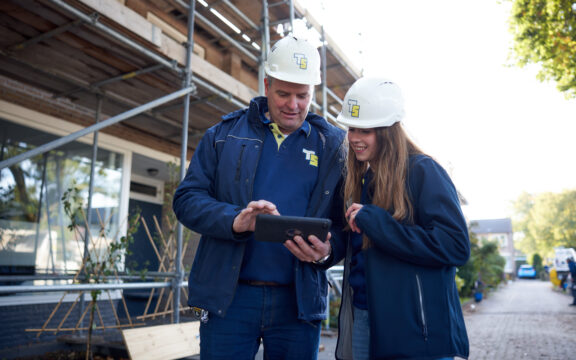 Uitvoerder en student op de bouw in overleg